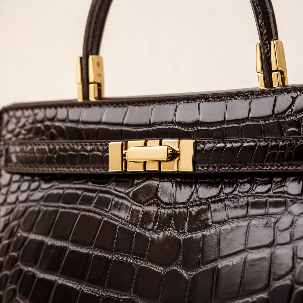 Gold turn-lock and croc-embossed leather, close up
