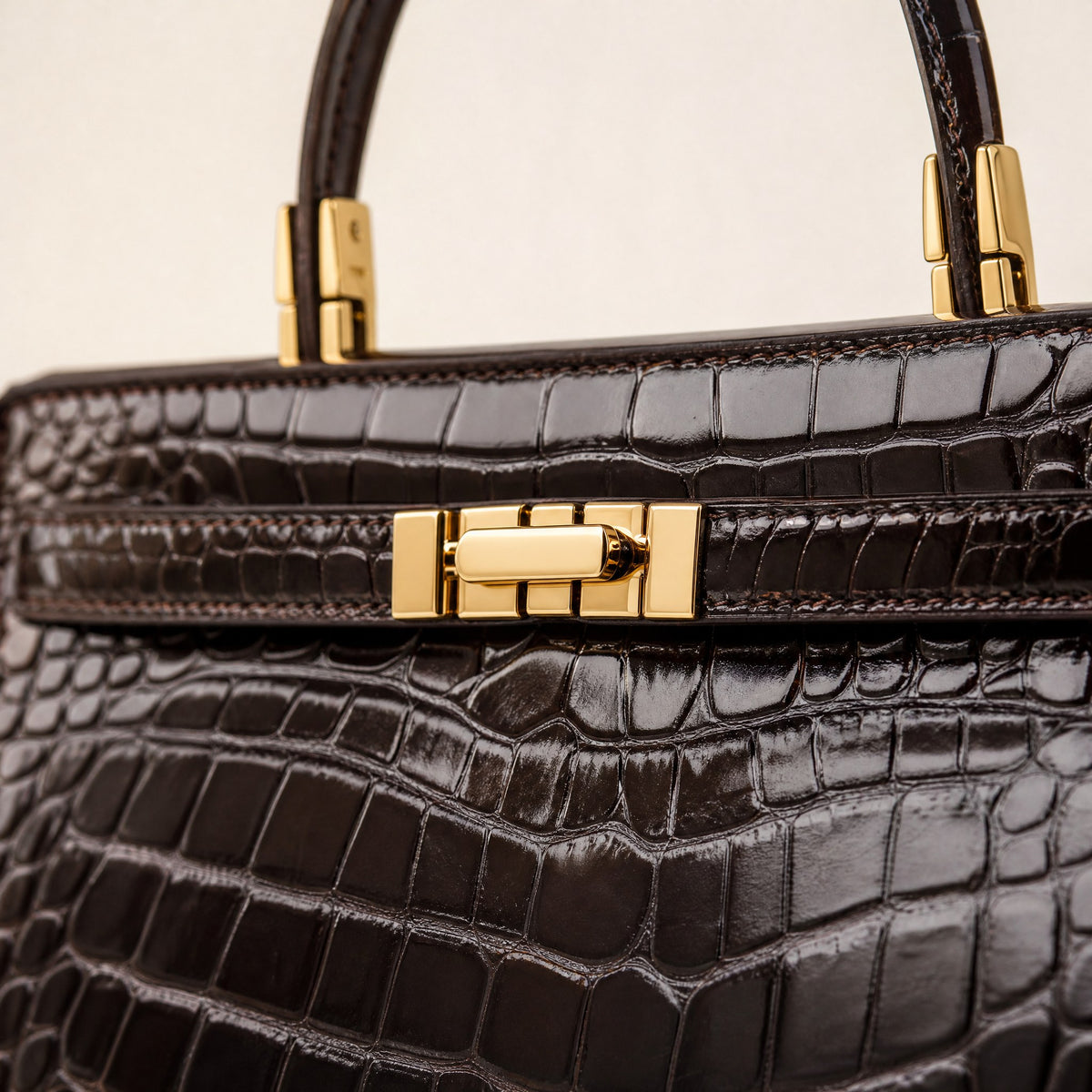 Gold turn-lock and croc-embossed leather, close up